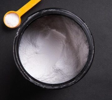 Creatina esportiva em um recipiente em um fundo preto vista de cima   Foto Premium 360x320