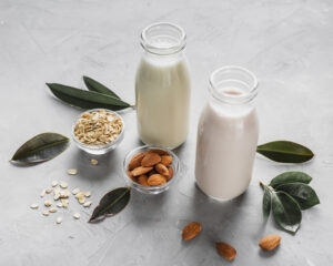High angle milk bottles with almonds oats 300x240